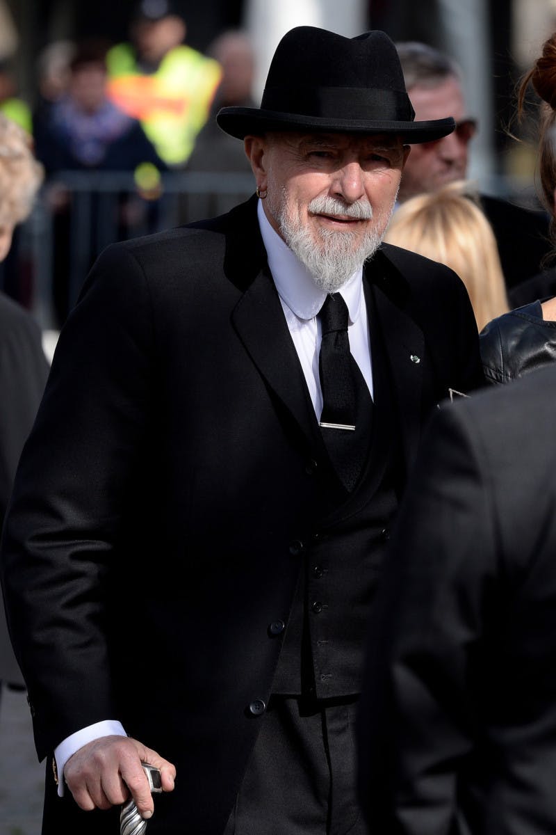 clothing tie person face suit overcoat coat hat tuxedo sunglasses